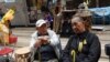 Mr. Wong, 90, dan Mr. Ng, 79, ada di antara kelompok terakhir demonstran di Causeway Bay, Hong Kong (15/12). (VOA/Iris Tong)