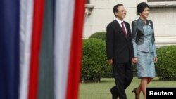 Chinese Premier Wen Jiabao (L) walks with Thai Prime Minister Yingluck Shinawatra during a welcoming ceremony at the Government House in Bangkok, November 21, 2012.