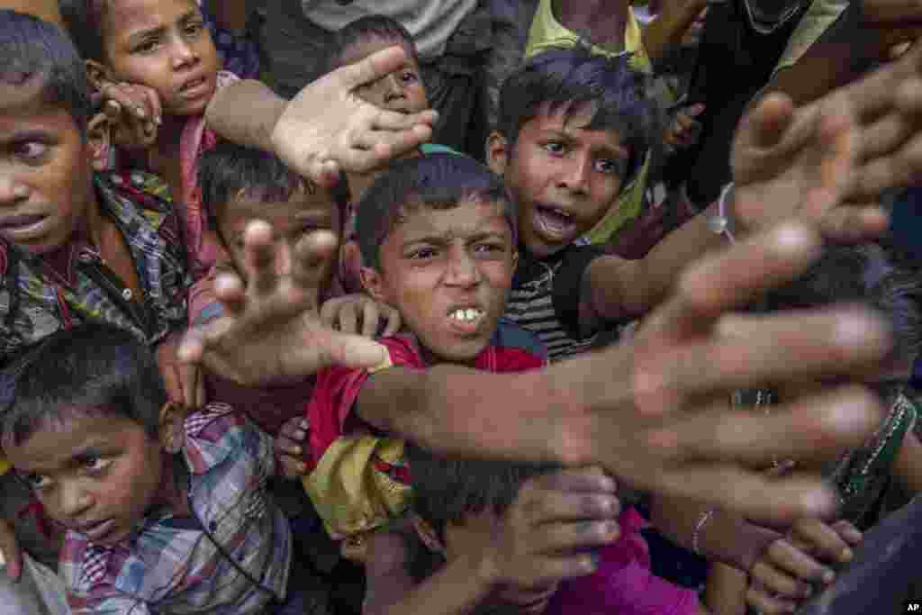 کودکان آواره روهینگیا دستان خود را برای دریافت شکلات و شیر که در کمپ پناهندگان در بنگلادش توزیع می شود، دراز کرده اند.