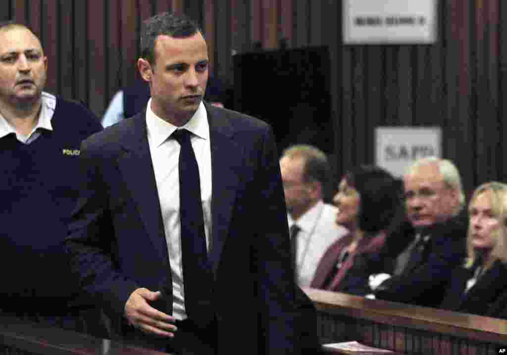 Oscar Pistorius is watched by June Steenkamp, right, the mother of Reeva Steenkamp, as he arrives for his trial at the high court in Pretoria, March 3, 2014.