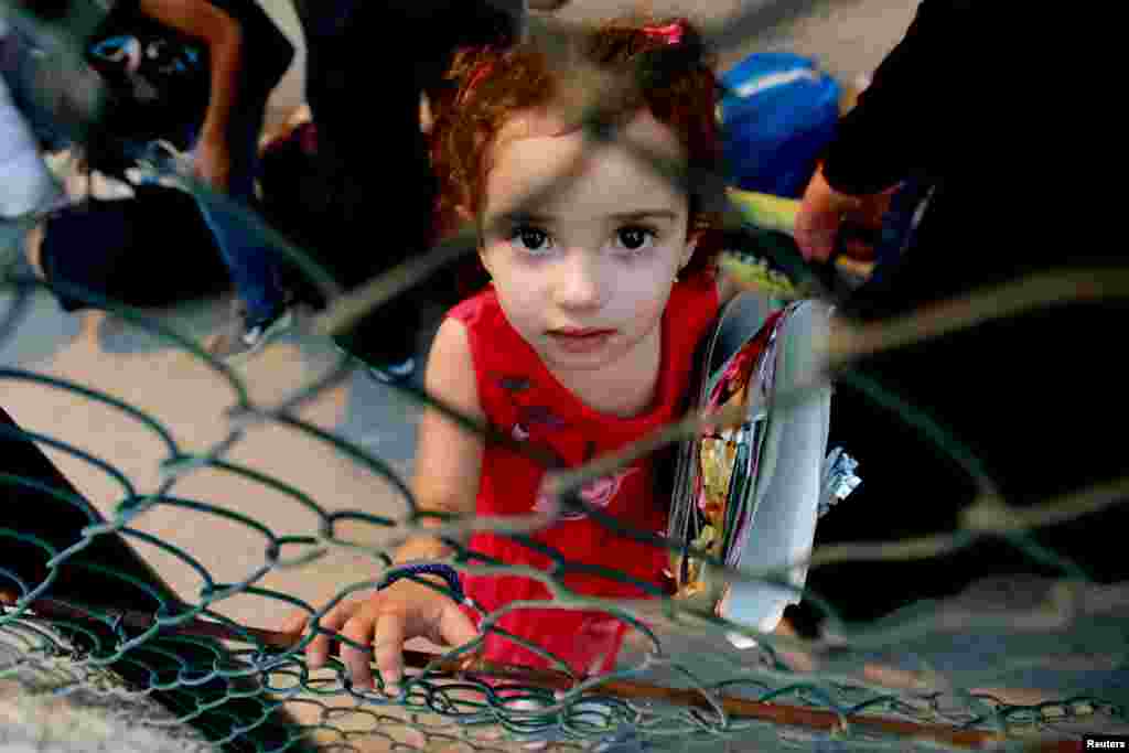 A Syrian girl waits as refugees prepare to leave the Lebanese capital Beirut to return to their homes in Syria.