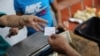 Una clienta paga en dólares en Caracas. [Foto: Reuters]