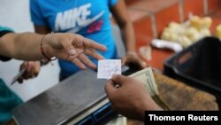 Una clienta paga en dólares en Caracas. [Foto: Reuters]