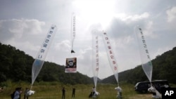 지난 2014년 한국 경기도 파주에서 탈북자 단체 관계자들이 북한 김정은 정권을 비판하는 내용의 전단을 실은 풍선을 북으로 날려보내고 있다. (자료사진)