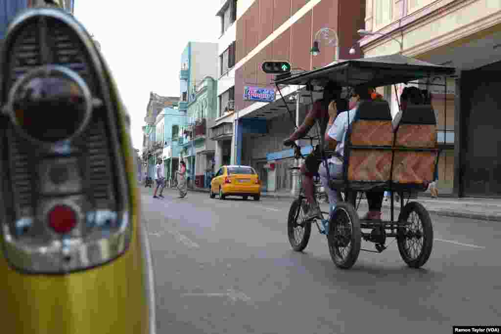 People take a pedicab through the streets of historic Havana.