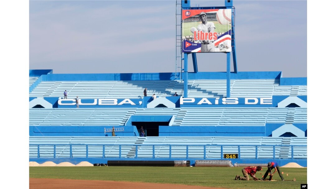 FILE - Workers are seen at the Latinoamericano baseball stadium ahead of an exhibition baseball game between the Cuban national team and U.S. team Tampa Bay Rays, in Havana, Cuba, March 16, 2016.