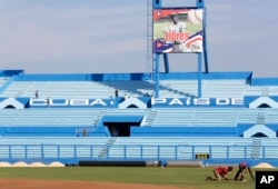 FILE - Workers are seen at the Latinoamericano baseball stadium ahead of an exhibition baseball game between the Cuban national team and U.S. team Tampa Bay Rays, in Havana, Cuba, March 16, 2016.