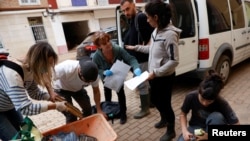 La Directora de Patrimonio de la Universidad de Valencia, María Luisa Vázquez de Agredos Pascual y otros restauradores y voluntarios recogen fotografías de vecinos afectados por las inundaciones para restaurarlas, en Aldaia, Valencia, España, 8 de noviembre de 2024. REUTERS