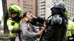 FILE - Police detain a man who was blocking traffic during a protest against a decree by Colombia's President Ivan Duque allowing police to confiscate any amount of drugs from people in the street in Bogota, Colombia, Sept. 6, 2018.