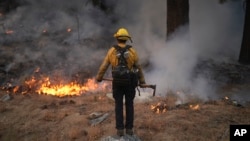 A firefighter works to contain the Bridge Fire in Wrightwood, California, Sept. 11, 2024.