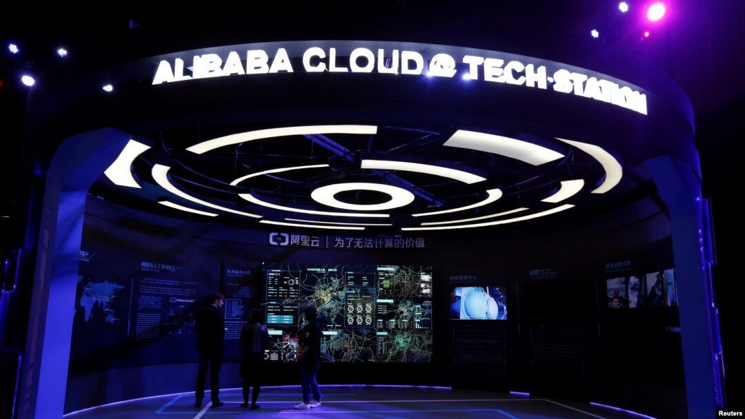 FILE - Visitors stand inside a booth introducing Alibaba Cloud services at an exhibition venue during Alibaba Group's 11.11 Singles' Day global shopping festival in Shenzhen, China, Nov. 11, 2016. 