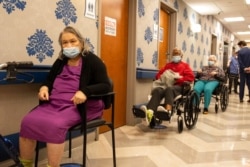 Nursing home residents make a line for the coronavirus disease vaccine at Harlem Center for Nursing and Rehabilitation, a nursing home facility, Jan. 15, 2021, in the Harlem neighborhood of New York.