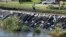 A worker walks across a levee overlooking the flood swollen Cedar River, Tuesday, Sept. 27, 2016, in Cedar Rapids, Iowa. An elaborate system of temporary floodwalls largely protected Cedar Rapids homes and businesses as the river reached its second-highest mark ever.