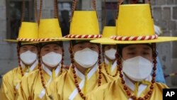 Imperial guards wear protective face masks during a reenactment of the Royal Guards Changing Ceremony in front of Deoksu Palace in Seoul, South Korea, Jan. 30, 2020.