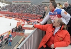 RUSSIA -- Russian President Vladimir Putin, foreground, watches downhill ski competition of the 2014 Winter Paralympics in Roza Khutor mountain district of Sochi, March 8, 2014