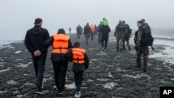 Un grupo de migrantes kurdos de Irán e Irak que fallaron en su intento para llegar a Reino Unido caminan de regreso a la localidad de Ambleteuse, en el norte de Francia, el 19 de mayo de 2024.