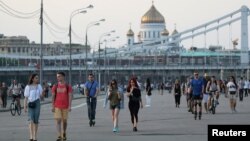 Orang-orang berjalan di Taman Gorky Central setelah pemerintah setempat mencabut sebagian pembatasan karantina yang diberlakukan untuk mencegah penyebaran virus Covid-19 di Moskow, Rusia 8 Juni 2020. 