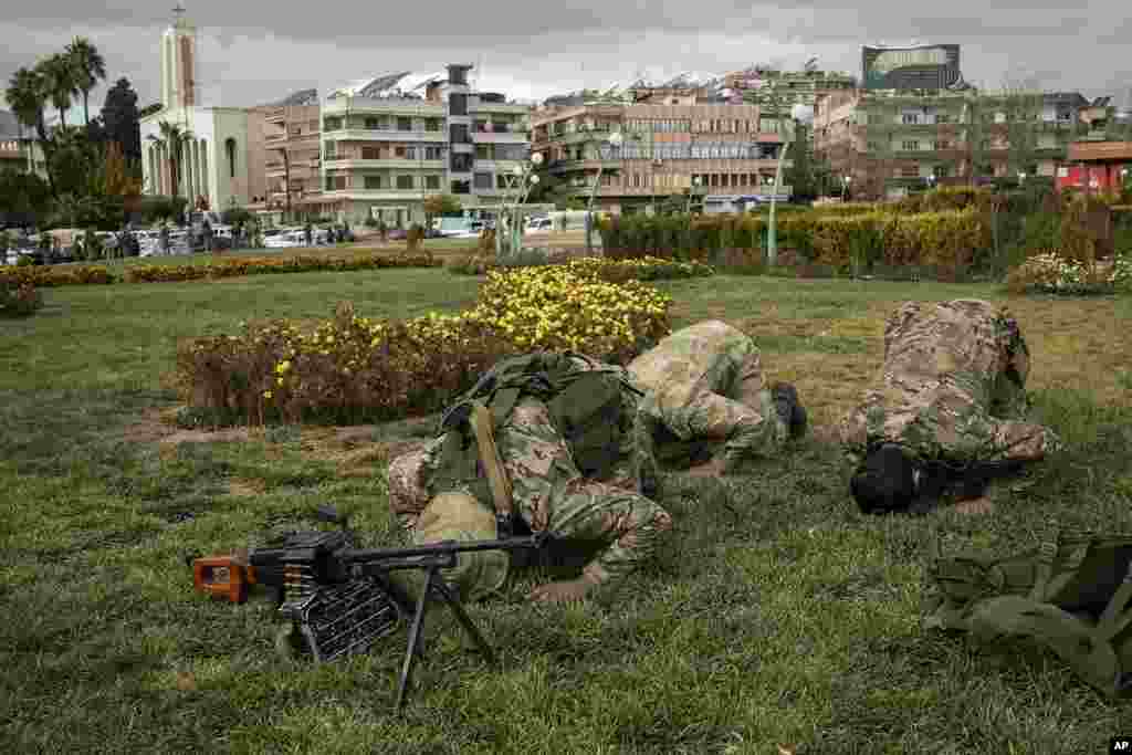 Members of the armed forces and former rebels, who overthrew Bashar al-Assad&#39;s government and now serve in the new Syrian government, pray before a military parade in downtown Damascus, Syria.