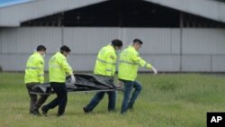 Petugas polisi membawa satu dari dua jenazah penumpang gelap yang jatuh dari ruang roda pesawat yang sedang lepas landas di Bandara Jose Joaquin de Olmedo di Guayaquil, Ekuador, Senin, 26 Februari 2018.