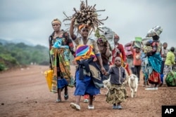 FILE - Residents flee fighting between M23 rebels and Congolese forces near Kibumba, some 20 kms (12 miles) North of Goma, Democratic republic of Congo, Oct. 29, 2022.