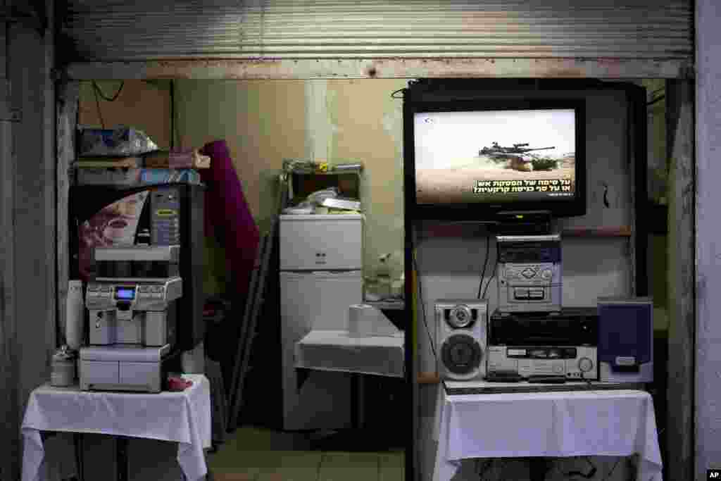 A TV screen shows the ongoing fighting between Israel and Gaza at the entrance to a coffee shop, in downtown, July, 2014, Tel Aviv, Israel.