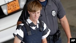 Charleston, S.C., shooting suspect Dylann Storm Roof is escorted from the Cleveland County Courthouse in Shelby, N.C., Thursday, June 18, 2015.