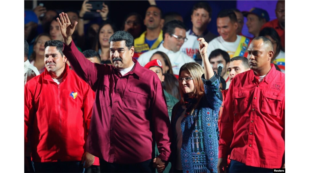 Venezuela's President Nicolas Maduro and his wife Cilia Flores wave to supporters after the National Electoral Council announced that with almost 93 percent of polling stations reporting, Maduro won nearly 68 percent of the votes in Sunday's election, beating his nearest challenger Henri Falcon by almost 40 points, in Caracas, Venezuela, May 20, 2018.