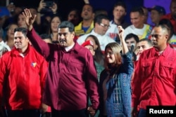 Venezuela's President Nicolas Maduro and his wife Cilia Flores wave to supporters after the National Electoral Council announced that with almost 93 percent of polling stations reporting, Maduro won nearly 68 percent of the votes in Sunday's election, beating his nearest challenger Henri Falcon by almost 40 points, in Caracas, Venezuela, May 20, 2018.