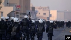 Riot police chase Bahraini anti-government protesters in the Shiite Muslim village of Sitra, Bahrain, January 1, 2012.