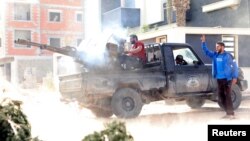 A member of the Libyan internationally recognized government forces fires during a fight with eastern forces in Ain Zara, Tripoli, Libya, April 25, 2019. 