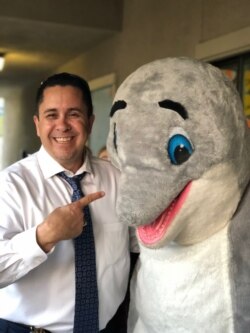 Dr. Reyes Gauna with dolphin character at a school in Byron Union School District in California.