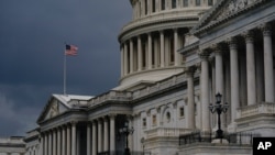 FILE - In this Aug. 3, 2020, file photo dark clouds and heavy rain sweep over the U.S. Capitol in Washington. The federal budget deficit is projected to hit a record $3.3 trillion 