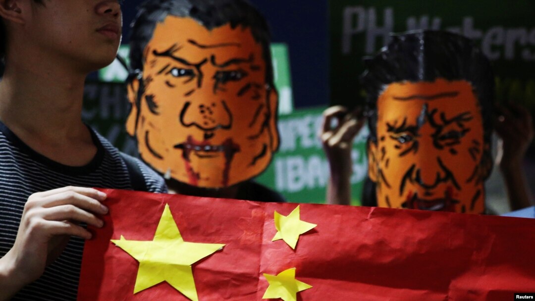 菲律宾学生头戴杜特尔特总统和中国国家主席习近平的漫画脸谱在马尼拉总统府外举行反华示威集会。（2018年11月20日）