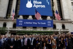FILE - Blue Apron CEO Matthew B. Salzberg, center, poses with employees in front of the New York Stock Exchange before the company's IPO in New York, U.S., in 2017.