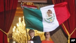 Mexico's President Felipe Calderon waves the national flag next to his wife Margarita Zavala, while thousands of Mexicans celebrate the 201st anniversary of the country's independence from Spain, September 15, 2011.