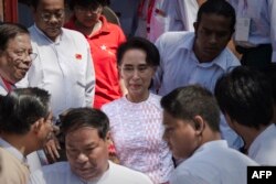 Myanmar opposition leader Aung San Suu Kyi, center, leaves the headquarters of the National League of Democracy (NLD) after she made a speech to a small crowd and the media in Yangon, Nov. 9, 2015.