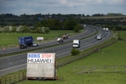 FILE - A sign reading "Boris Stop Huawei" is seen next to the M40 motorway, Tetsworth, Britain, May 1, 2020, in a reference to Prime Minister Boris Johnson.