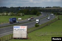 FILE - A sign reading "Boris Stop Huawei" is seen next to the M40 motorway, Tetsworth, Britain, May 1, 2020, in a reference to British Prime Minister Boris Johnson.