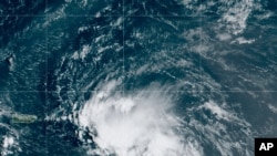 This satellite image released by the National Oceanic and Atmospheric Administration (NOAA) shows Tropical Storm Laura in the North Atlantic Ocean, Aug. 21, 2020.