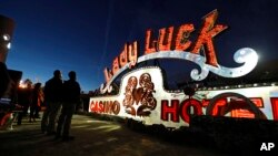 In this Jan. 24, 2018, photo, projectors light up non-working neon signs at an exhibit at the Neon Museum in Las Vegas. Starting this week, visitors will be able to see many of the city's classic neon signs just like they were decades ago through a type of augmented reality that projects realistic animations onto the non-working signs. (AP Photo/John Locher)