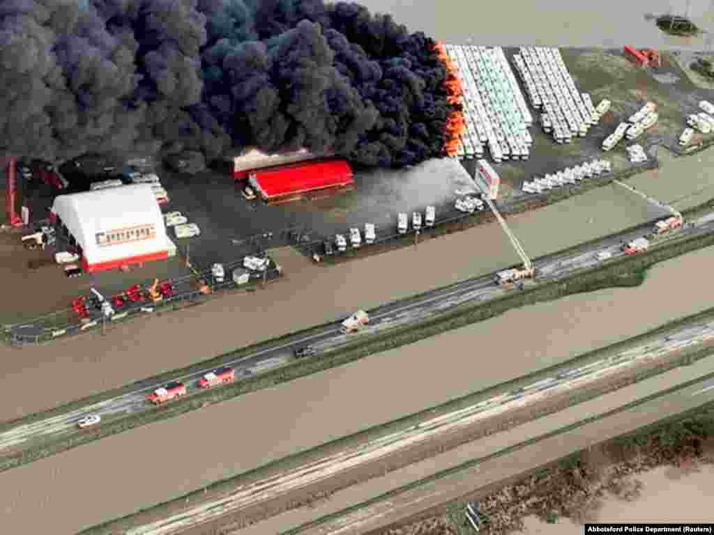 Fire burns at an RV storage lot surrounded by flood waters in Abbotsford, British Columbia, Canada, Nov. 17, 2021.