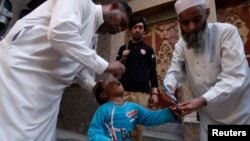 Petugas kesehatan Pakistan memberikan vaksin polio kepada seorang anak di Peshawar (foto: dok).