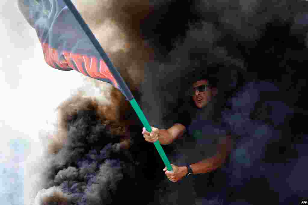 A protester waves a flag of the "Plataforma Caracol" taxi association during a strike by taxi drivers in Barcelona.