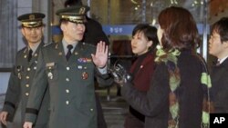 South Korean delegate Army Col. Moon Sang-gyun, second from left, is questioned by reporters as he leaves for military meeting with North Korea in Seoul, South Korea, February 8, 2011.