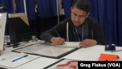 Houston high school teacher Eden Bautista sketched at his booth while waiting for people at Comicpalooza to stop by and check out his work, in Houston.