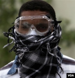 Seorang pemuda di Manama, Bahrain, siap menghadapi gas air mata yang sering digunakan aparat untuk membubarkan para demonstran.