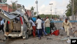 A Somali policeman runs through the wreckage outside the Sahafi Hotel in Mogadishu, Somalia, Nov. 1, 2015.