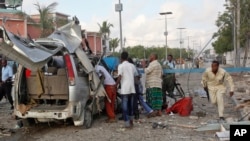 Somali policeman runs through wreckage outside the Sahafi Hotel, Mogadishu, Nov. 1, 2015.