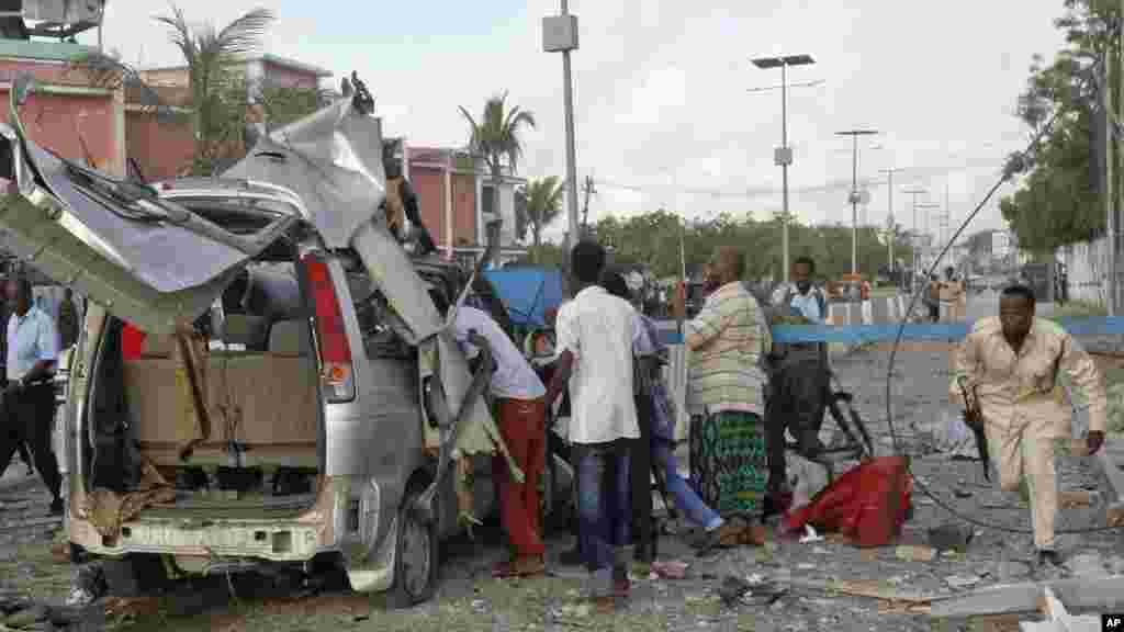 A Somali policeman runs through the wreckage outside the Sahafi Hotel in Mogadishu, Somalia, Nov. 1, 2015.