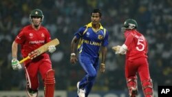 Sri Lankan bowler Nuwan Kulasekara, center, runs along with Zimbabwe's batsmen Brendan Taylor, left, and Regis Chakabva during the Cricket World Cup match between Sri Lanka and Zimbabwe in Pallekele, Sri Lanka, Thursday, March 10, 2011. (AP Photo/Eranga J